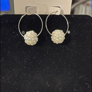 Sterling silver hoop earrings with a symbolic pendant